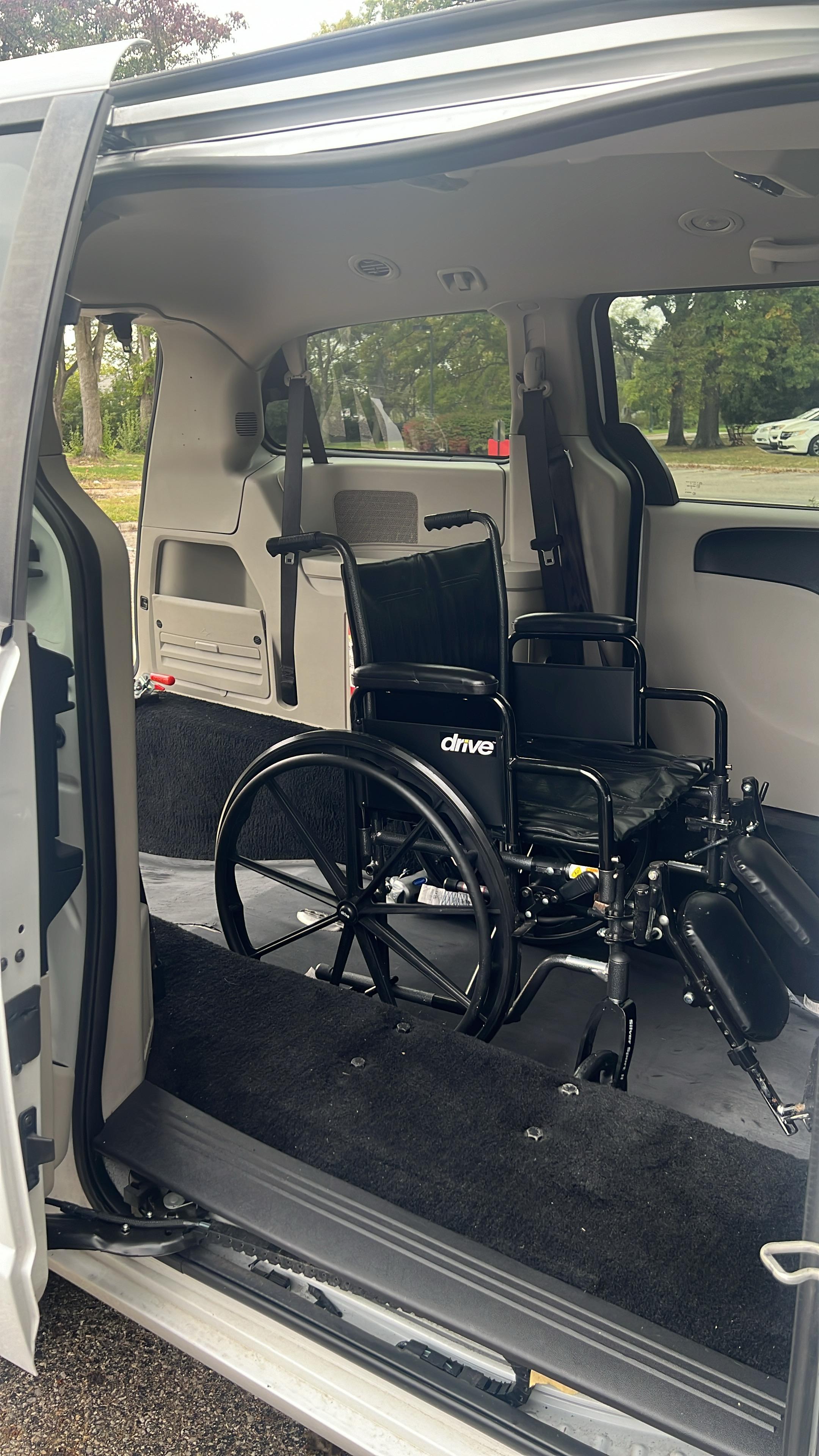 Patient being assisted into a K Poku Transport vehicle
